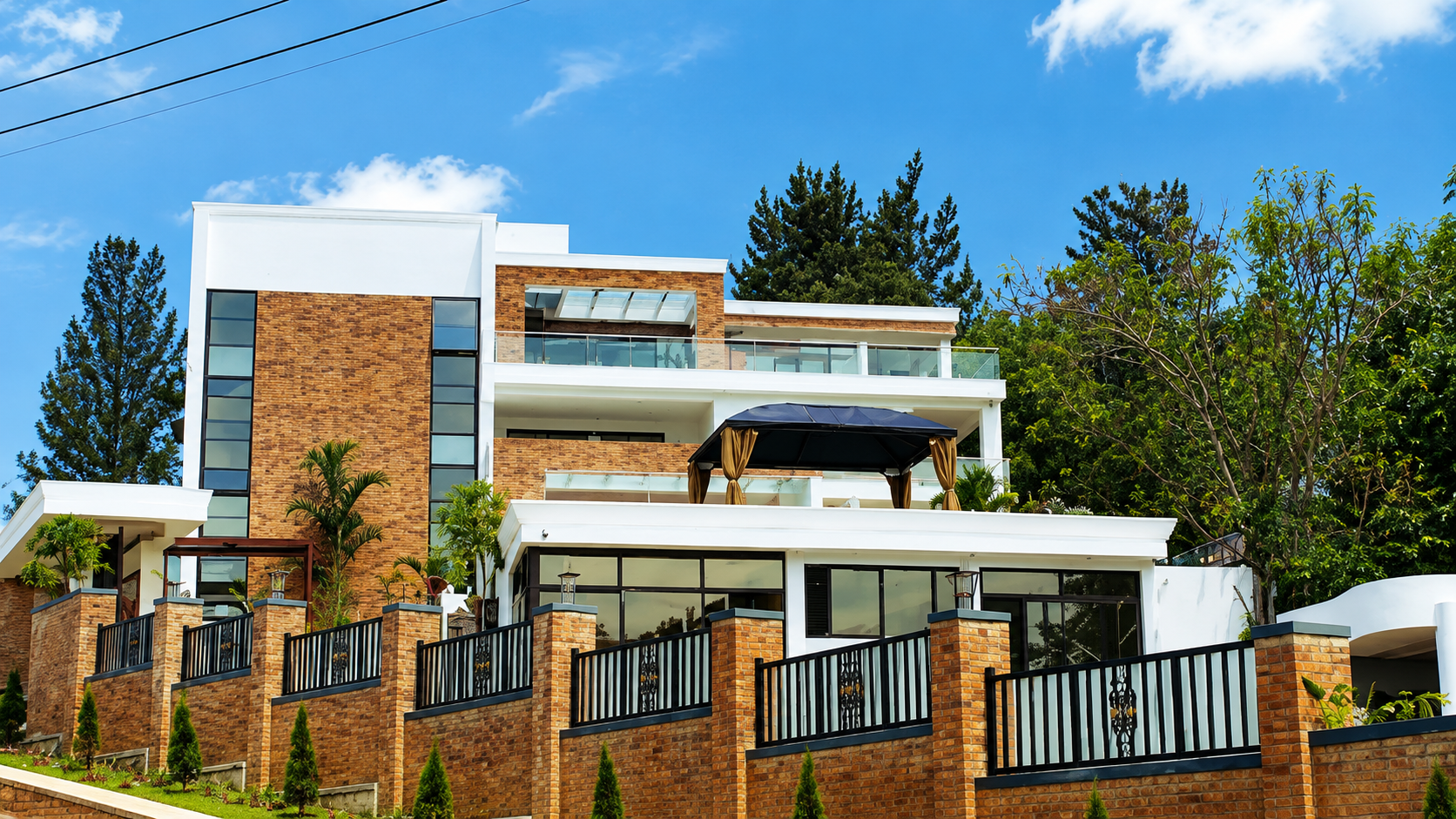 Completed multi-storey residential villa in brick and render, with terraces and boundary walling